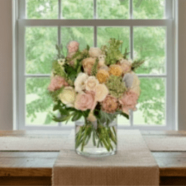 Pastel rose bouquet in a clear glass vase on a table