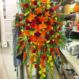 Tall standing floral spray with red, orange, and yellow flowers