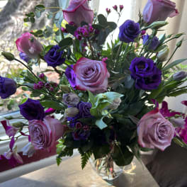Bouquet of pink and purple roses in a clear glass vase