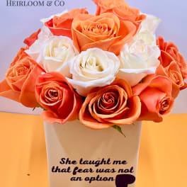 Orange and white roses arranged in a white vase with printed text