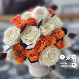 Bouquet of white and orange roses in a white vase