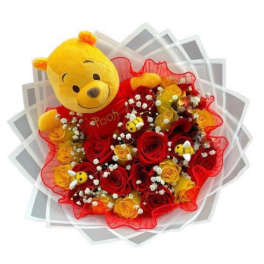 Bouquet of red and yellow roses with a Winnie the Pooh plush