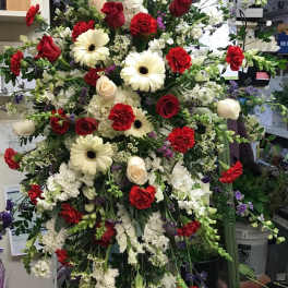 Large standing floral spray with red, white, and purple blooms