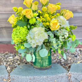Yellow roses and white hydrangeas in a glass vase