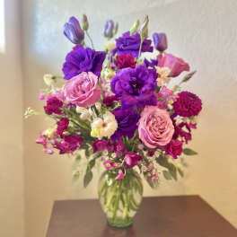 Bouquet of pink and purple flowers in a clear glass vase