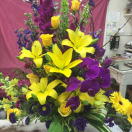 Tall bouquet with yellow lilies, purple orchids, and yellow roses