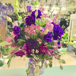 Tall bouquet of pink and purple flowers in a clear vase