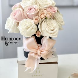 Bouquet of pale pink and white roses tied with a blush ribbon