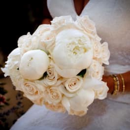 Bride holding a white bouquet of roses and peonies