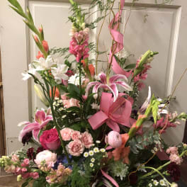 Tall mixed flower basket with pink ribbon and butterfly topper