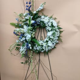 White and blue floral wreath on a black easel