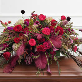 Large red and magenta floral arrangement with calla lilies and roses
