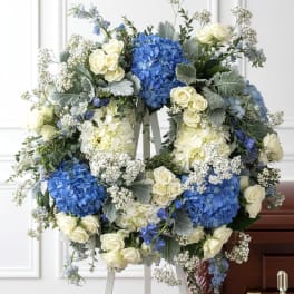 Blue and white floral funeral wreath on an easel