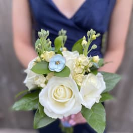 Small bouquet of white roses and pale flowers with a blue accent bloom