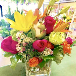 Colorful bouquet of lilies and roses in a clear glass vase