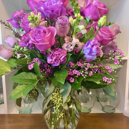Pink and purple rose bouquet in a glass vase