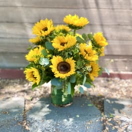 Bouquet of yellow sunflowers in a green vase