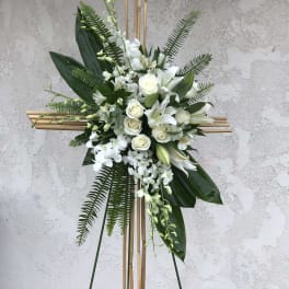 White floral standing spray on a bamboo cross frame