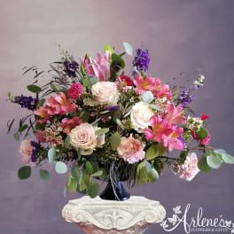 Pink and white floral arrangement in a black vase