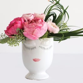 Pink flowers arranged in a white face-shaped vase