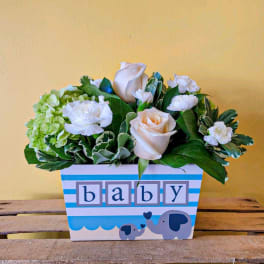 Baby-themed flower arrangement in a decorated box with roses and carnations