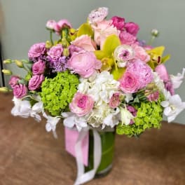 Pink and white mixed bouquet in a glass vase with green hydrangeas
