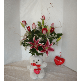 Bouquet of pink roses and lilies with a teddy bear and heart ornaments
