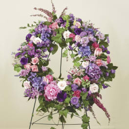 Large purple and pink floral wreath on a metal stand