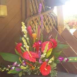 Tropical floral arrangement with red anthuriums and purple orchids