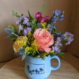 Mixed bouquet in a light blue mug-style vase
