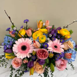 Colorful bouquet with pink gerbera daisies, roses, and yellow ranunculus