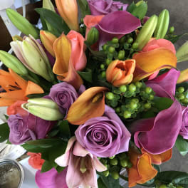 Bouquet of purple roses, orange lilies, and pink calla lilies