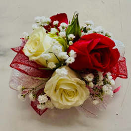 Small bouquet of red and cream roses with white filler flowers and red ribbon