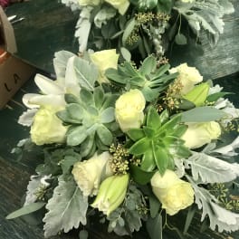 Two pale yellow rose and succulent bouquets on a dark table