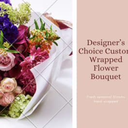 Wrapped bouquet of mixed pink, purple, and orange flowers