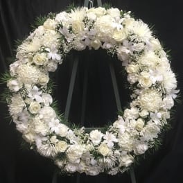 White floral wreath on a black easel
