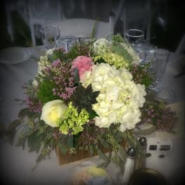 Large floral centerpiece with white and pink blooms in a low container