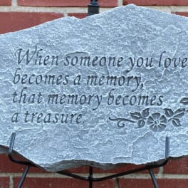 Engraved memorial stone with a sympathy quote on a stand