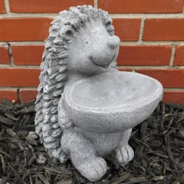 Stone hedgehog garden statue holding a shallow bowl