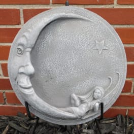 Round gray moon plaque with a face and reclining figure