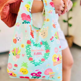 Reusable tote bag with pastel blue background and cheerful floral and fruit cartoons