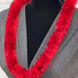 Fluffy red garland-style lei displayed on a black dress form in a gray top