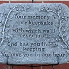 Memorial plaque with engraved text and vine border on a brick wall