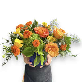 Orange and yellow mixed bouquet in a blue vase