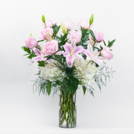 Pink roses and lilies in a clear glass vase
