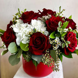 Red roses and white hydrangeas in a red vase
