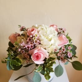 Pink roses and white hydrangeas arranged in a white vase