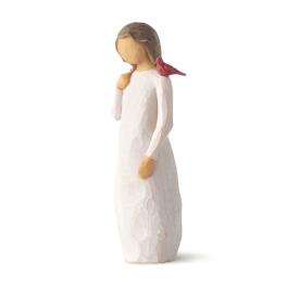 Small angel figurine in a white dress with a red bird on her shoulder