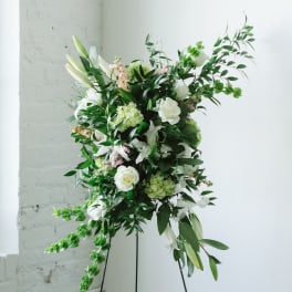 Tall white floral arrangement on a black stand