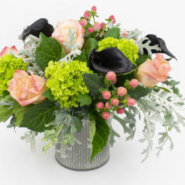 Bouquet of peach roses, green hydrangeas, and black calla lilies in a gray vase